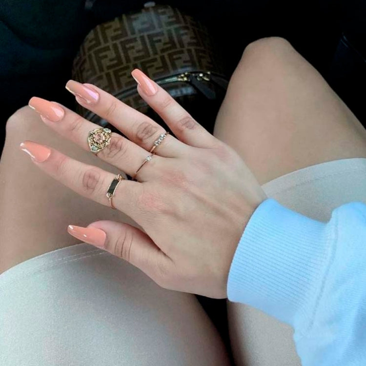 Gel Fantasy Nails - Ab Fab in zachte perzikkleur, lange nagels met een glanzende afwerking, gedragen op een hand.