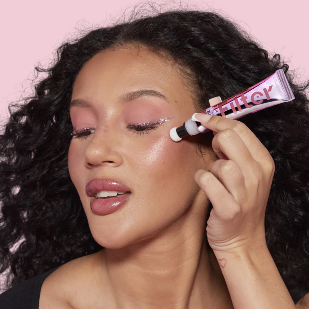 Filter Finish Liquid Blush Light Wand in een tube, aangebracht op de wang van een vrouw met krullend haar en een zachte ma...