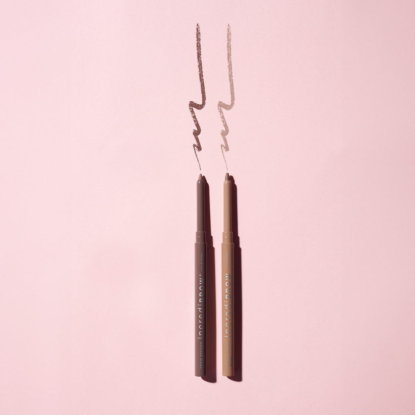 Incredibrow Eyebrow Definer - Blonde, een slanke potloodvormige brow definer in een lichte blonde tint op een roze achterg...