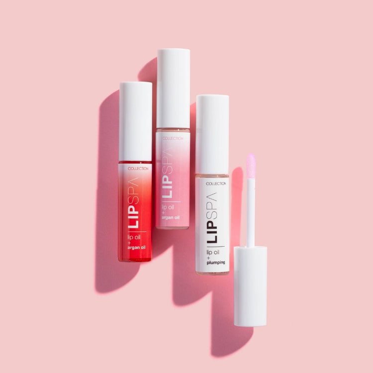 Lip Spa Lip Oil in drie kleuren (rood, roze, transparant) met een applicator in een strakke, witte verpakking.