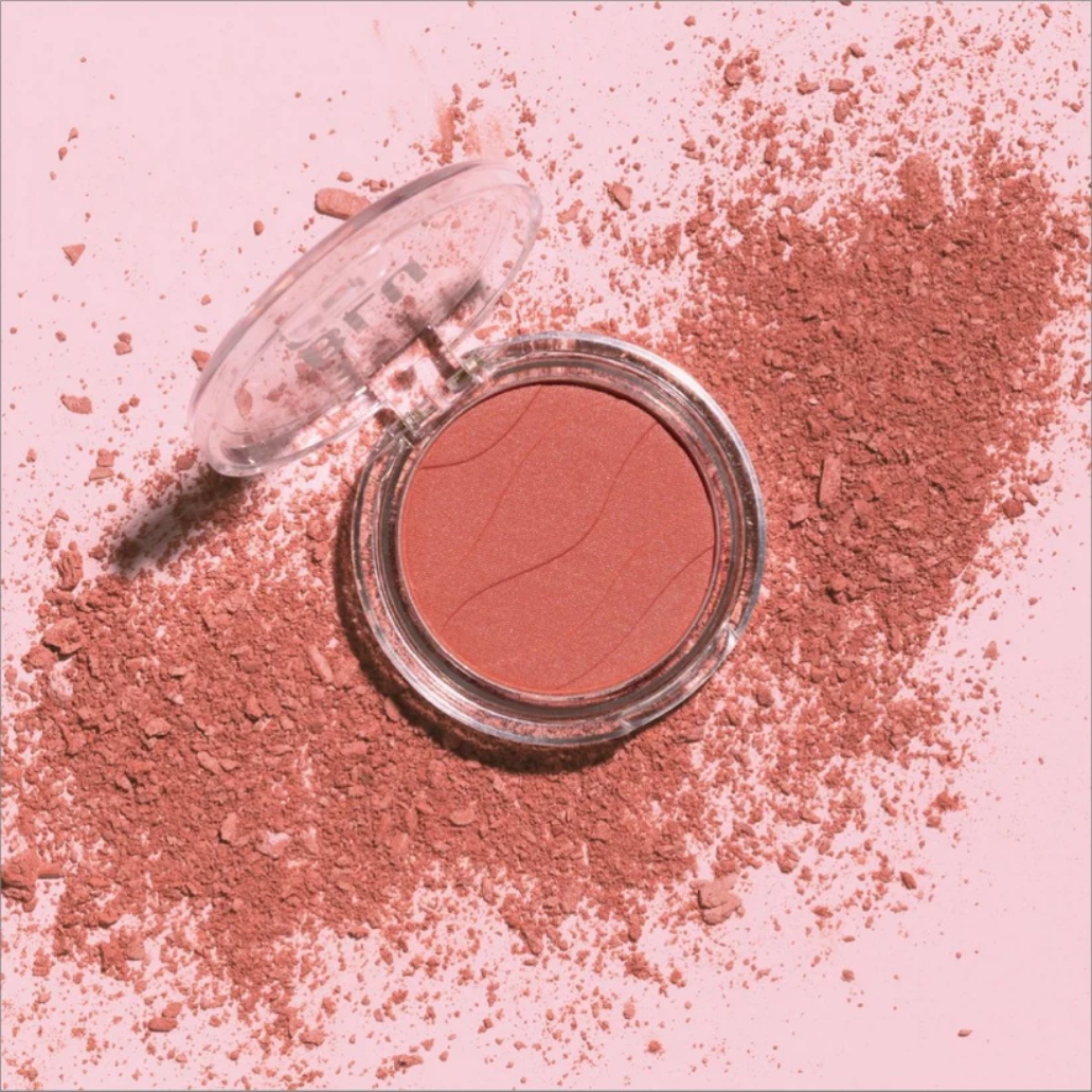 Soft Glow Blusher in een ronde, doorzichtige verpakking met een zachte, perzikachtige kleur en poederachtige textuur.